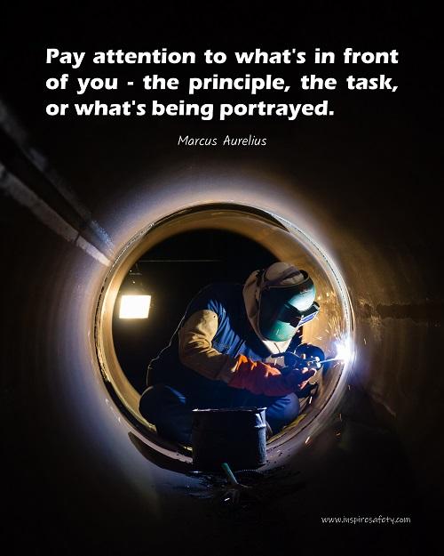 Safety poster of a welder in safety gear and hood sitting inside a large pipe; they are welding with bright sparks flying and a safety quote in white text at the top.