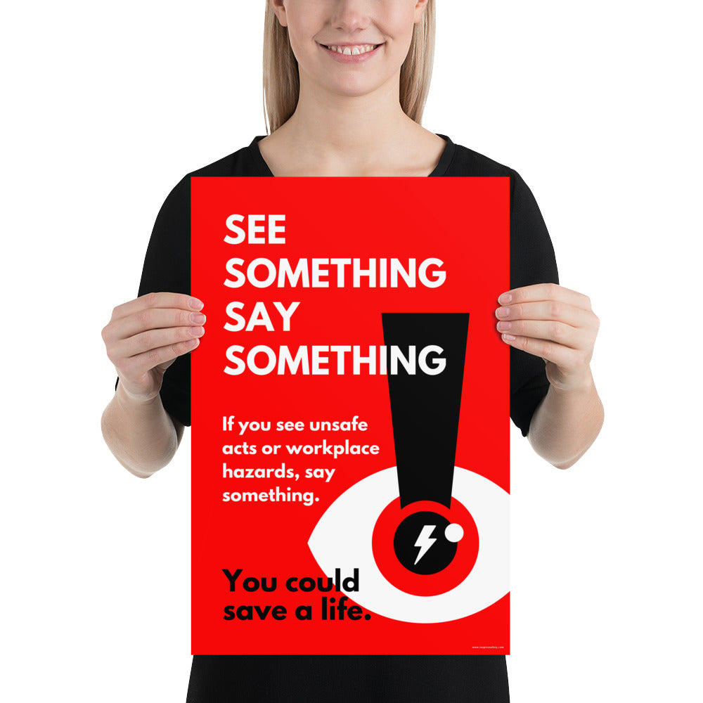 A workplace safety poster with a bright red background an an eye with an exclamation point coming from the pupil and a lightning bolt in the middle of the pupil with text that says "See Something Say Something" in bold lettering with the words "If you see unsafe acts or workplace hazards, say something. You could save a life."