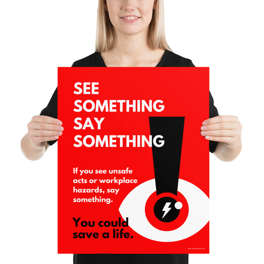 A workplace safety poster with a bright red background an an eye with an exclamation point coming from the pupil and a lightning bolt in the middle of the pupil with text that says "See Something Say Something" in bold lettering with the words "If you see unsafe acts or workplace hazards, say something. You could save a life."