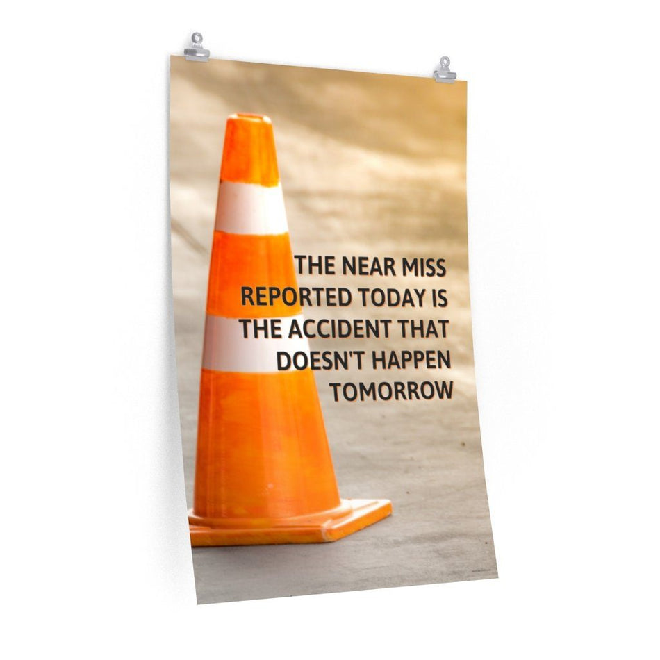 A workplace safety poster showing an orange safety cone with the slogan the near miss reported today is the accident that doesn't happen tomorrow.