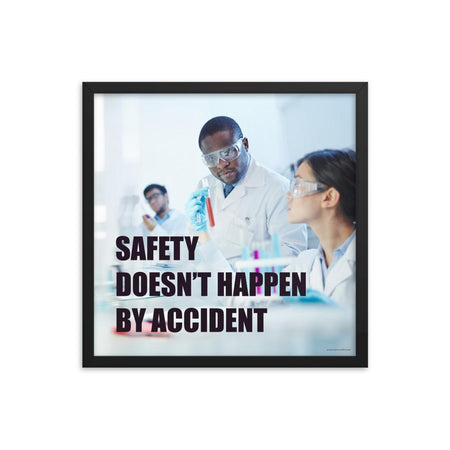 Male and female workers wearing lab coats and safety glasses while inspecting a test tube with a safety slogan written in bold text.