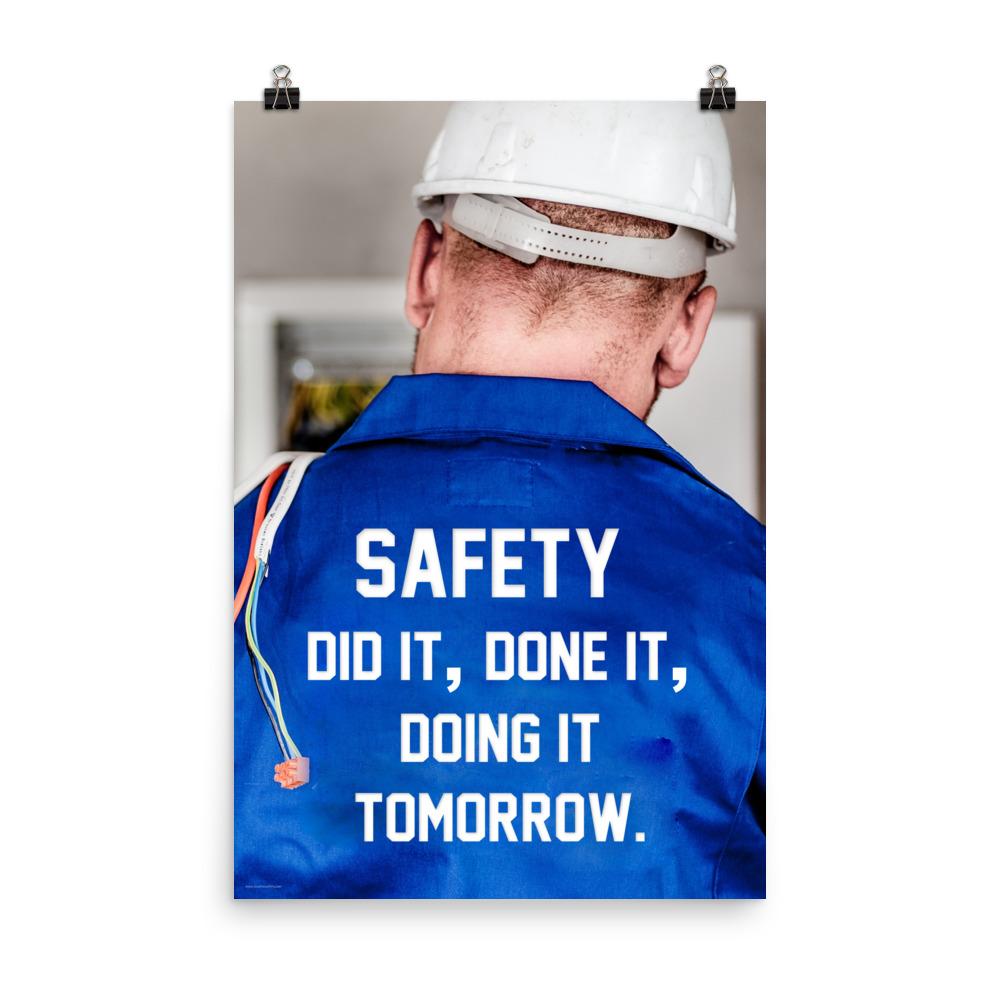 Safety poster showing an electrician wearing a hard hat and holding cables working on an electrical panel with text on the back of his bright blue shirt.