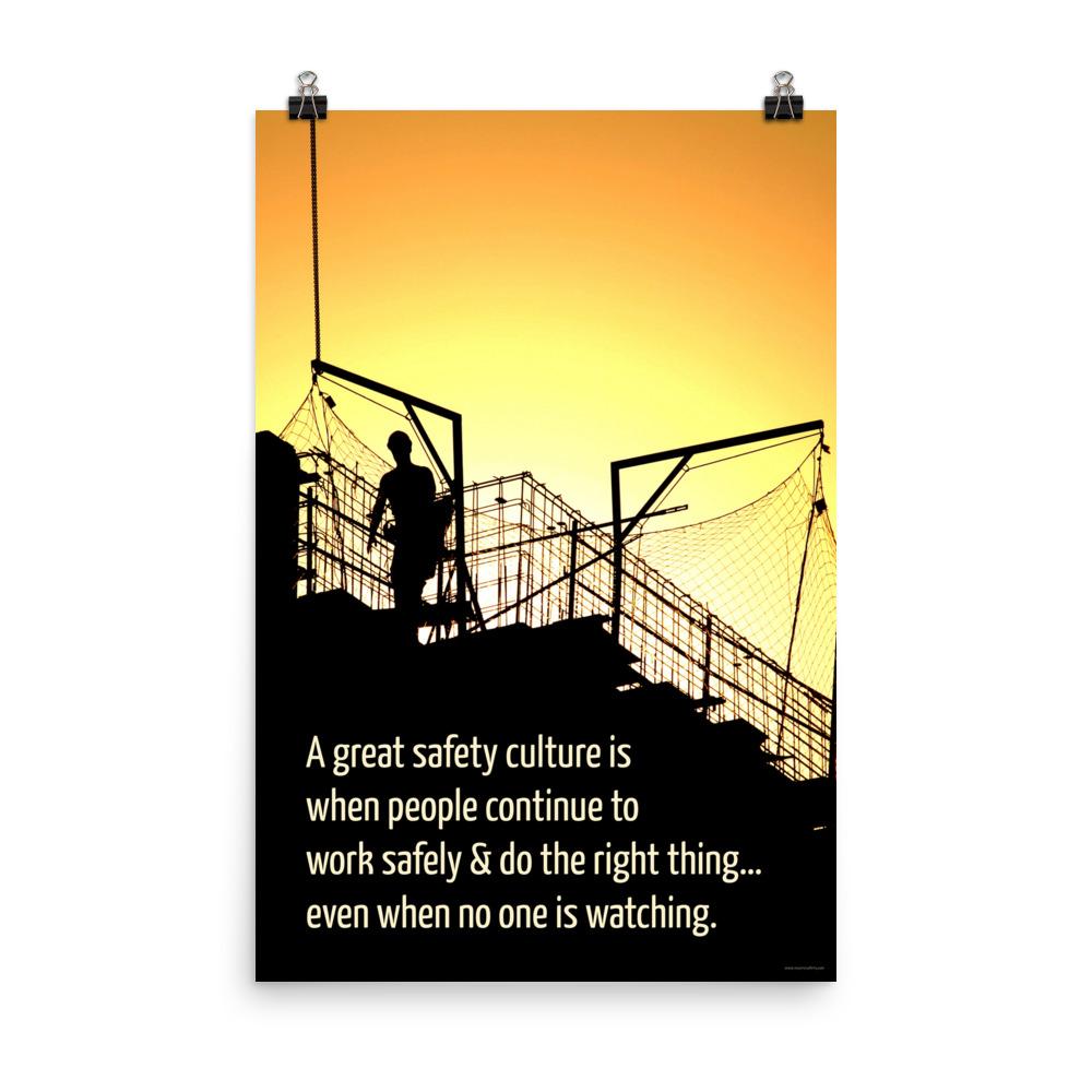 A construction safety poster showing the silhouette of a construction worker working on a building with a bright yellow sunset in the background and a safety slogan in the bottom left corner.