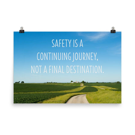 A workplace safety poster depicting a beautiful sunny day with a bright blue sky and a lush green field being cut down the middle by a dirt road leading off into the countryside with the text safety is a continuing journey, not a final destination.