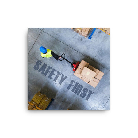 A safety poster showing a bird's-eye view of a worker in a warehouse pulling boxes on a pallet jack with the slogan safety first in bold letters.