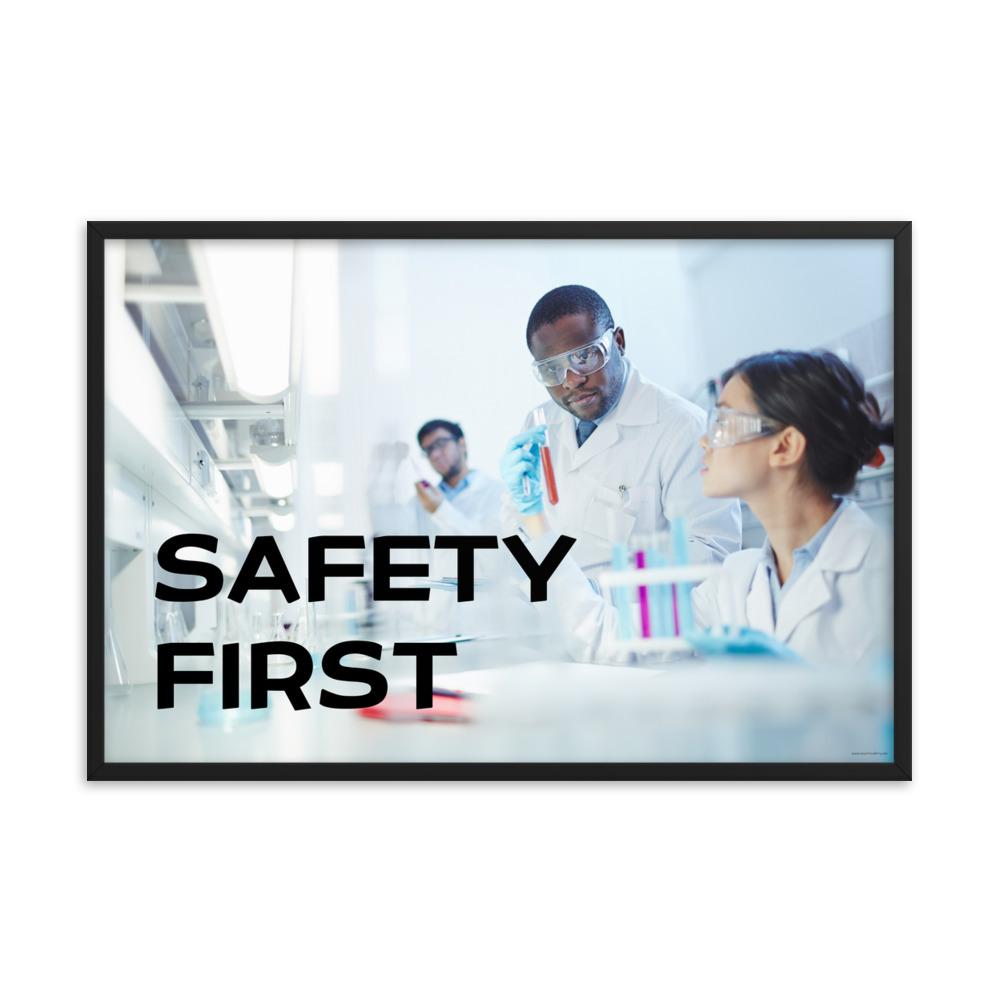 A safety poster showing two lab workers collaborating on a project in a lab while wearing full PPE with the slogan safety first.