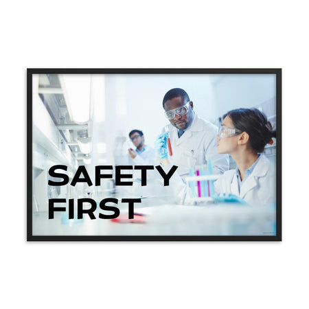 A safety poster showing two lab workers collaborating on a project in a lab while wearing full PPE with the slogan safety first.
