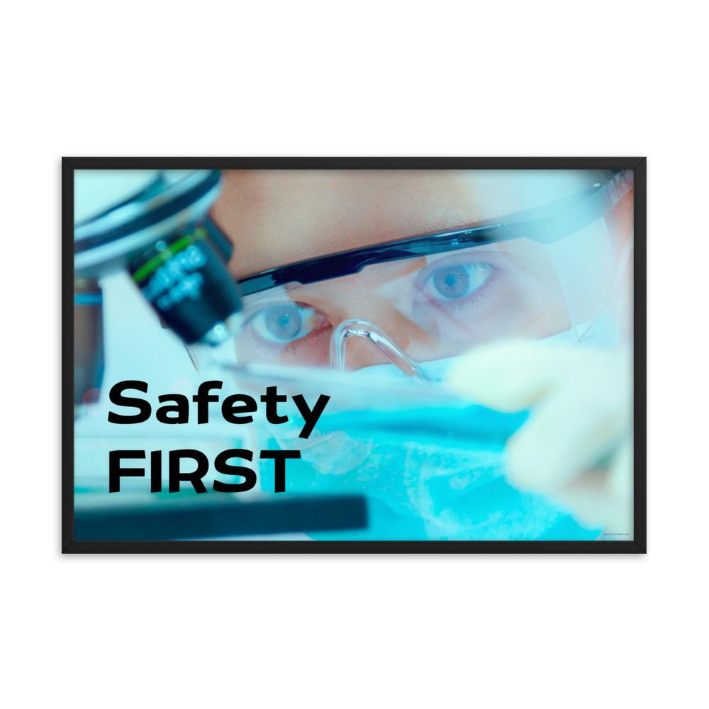 A safety poster showing a close up of a lab worker's eyes examining a sample on a microscope while wearing safety glasses and a mask with the slogan safety first in bold letters.