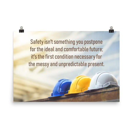 A workplace safety poster showing 3 multi colored hardhats sitting on a wall with the slogan safety isn't something you postpone for the ideal and comfortable future. It's the first condition necessary for the messy and unpredictable present.
