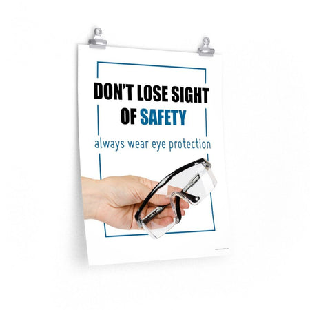 An eye safety slogan showing a close up of a hand presenting out safety glasses with a safety slogan in blue text above.