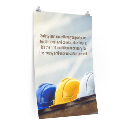 A workplace safety poster showing 3 multi colored hardhats sitting on a wall with the slogan safety isn't something you postpone for the ideal and comfortable future. It's the first condition necessary for the messy and unpredictable present.