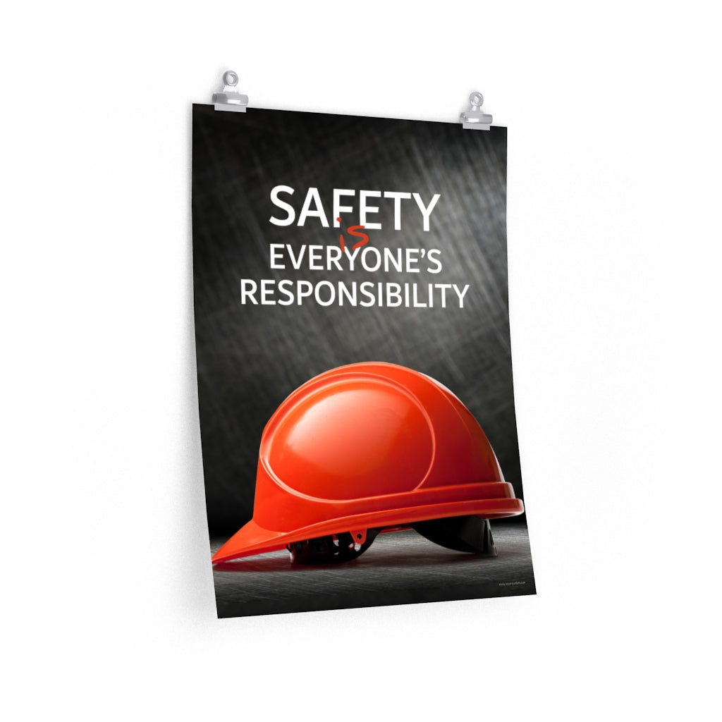 A workplace safety poster showing a red hard hat in front of a grey, industrial-looking background with the slogan safety is everyone's responsibility.