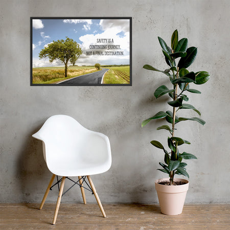 A workplace safety poster depicting a beautiful sunny day with a bright blue sky and a lush green field being cut down the middle by a road leading off into the countryside with the text safety is a continuing journey, not a final destination.