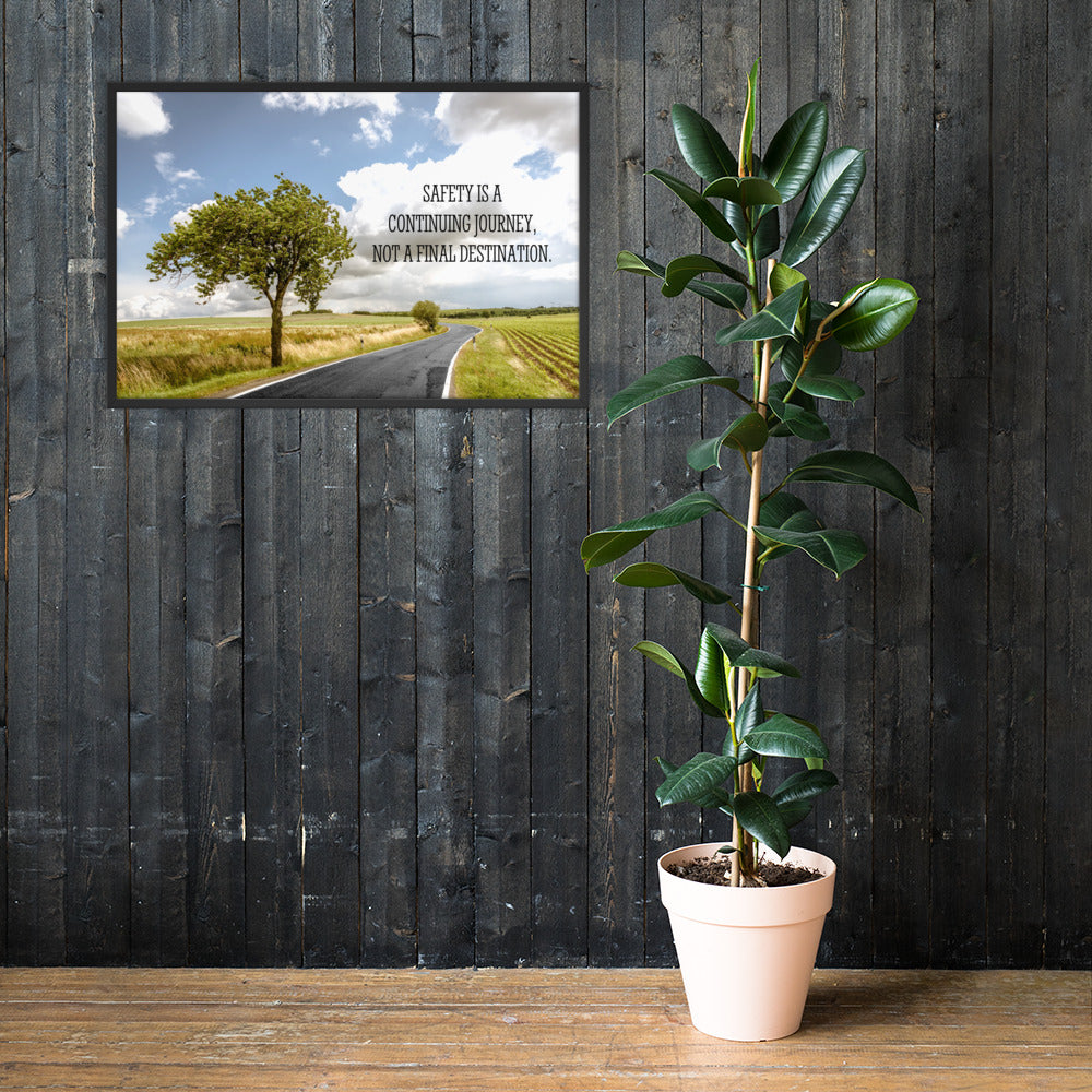 A workplace safety poster depicting a beautiful sunny day with a bright blue sky and a lush green field being cut down the middle by a road leading off into the countryside with the text safety is a continuing journey, not a final destination.
