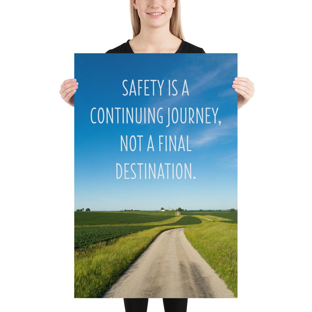 A workplace safety poster depicting a beautiful sunny day with a bright blue sky and a lush green field being cut down the middle by a dirt road leading off into the countryside with the text safety is a continuing journey, not a final destination.