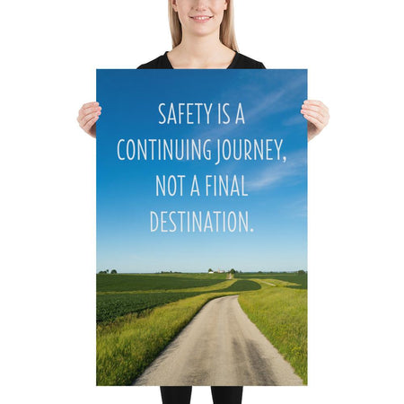 A workplace safety poster depicting a beautiful sunny day with a bright blue sky and a lush green field being cut down the middle by a dirt road leading off into the countryside with the text safety is a continuing journey, not a final destination.