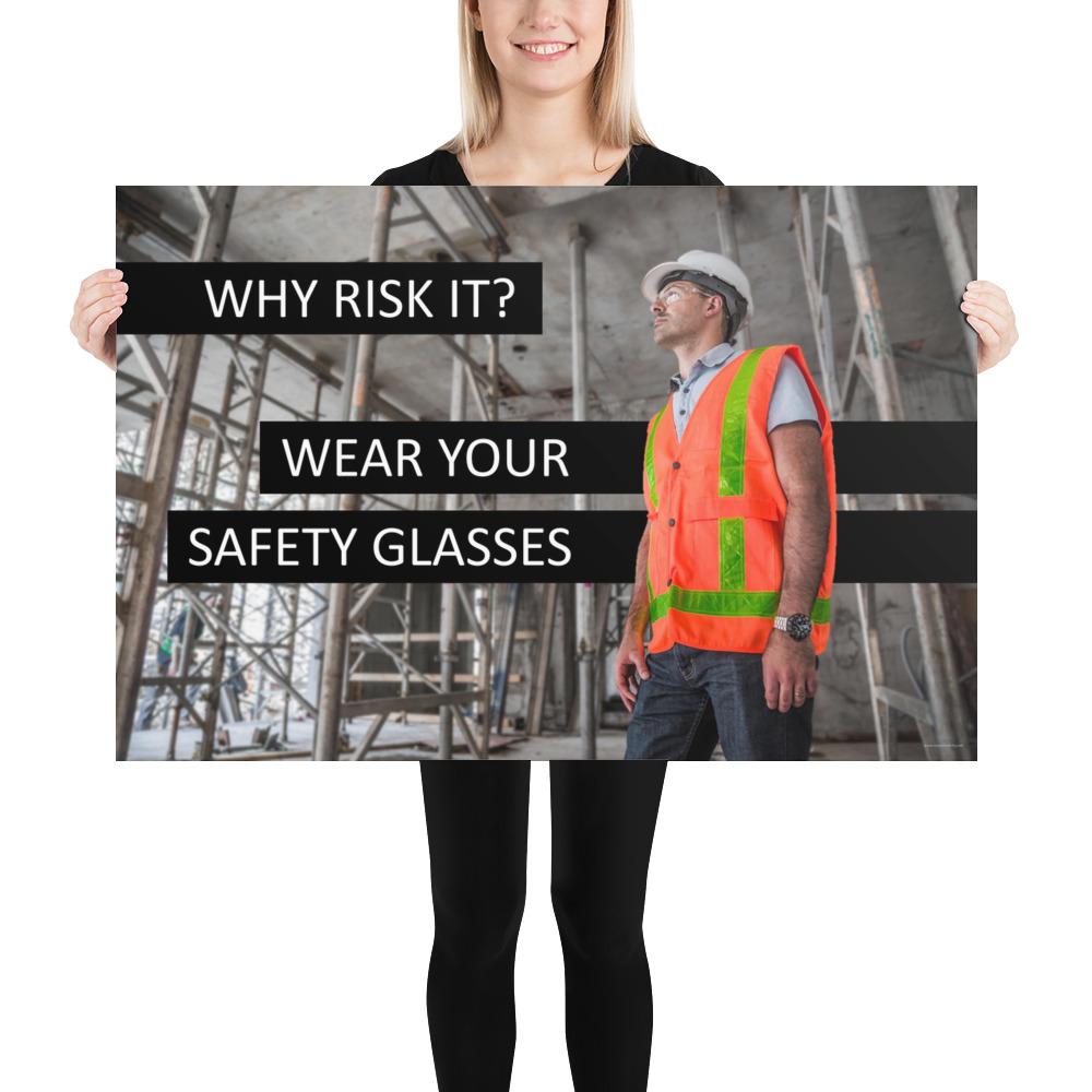 A safety poster showing a construction worker in a reflective orange vest, hard hat, and safety glasses on a construction site looking out with a safety slogan to the left.