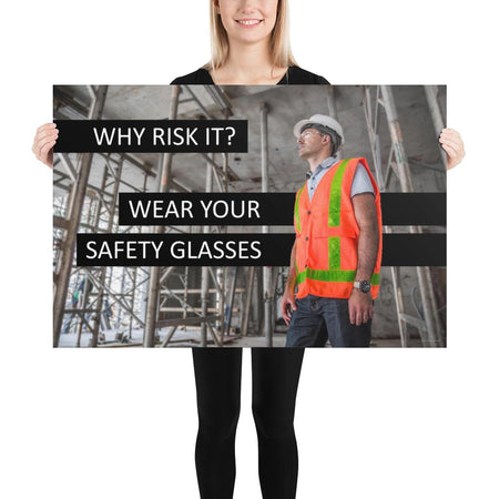 A safety poster showing a construction worker in a reflective orange vest, hard hat, and safety glasses on a construction site looking out with a safety slogan to the left.