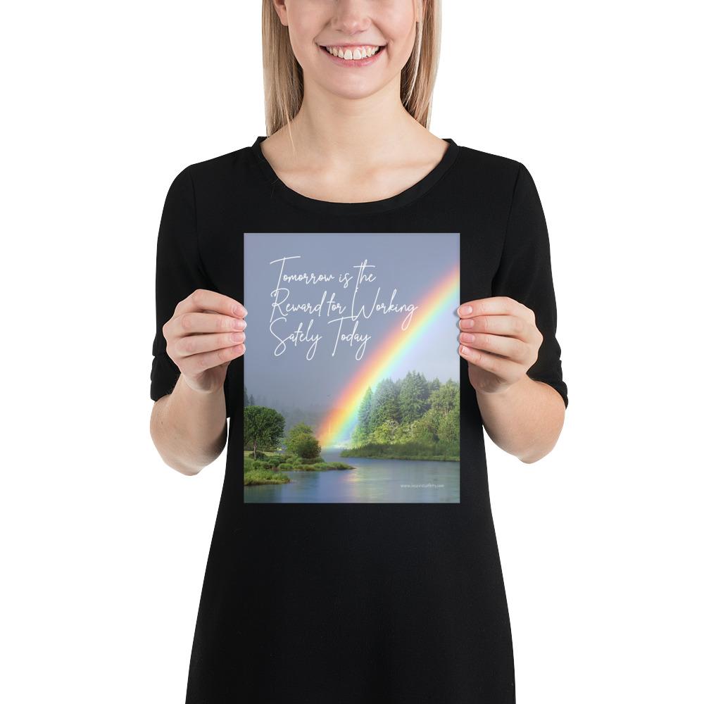 A workplace safety poster showing bright forest scene with a lake and vibrant green trees and a colorful rainbow coming out of the forest with the slogan tomorrow is the reward for working safely today.