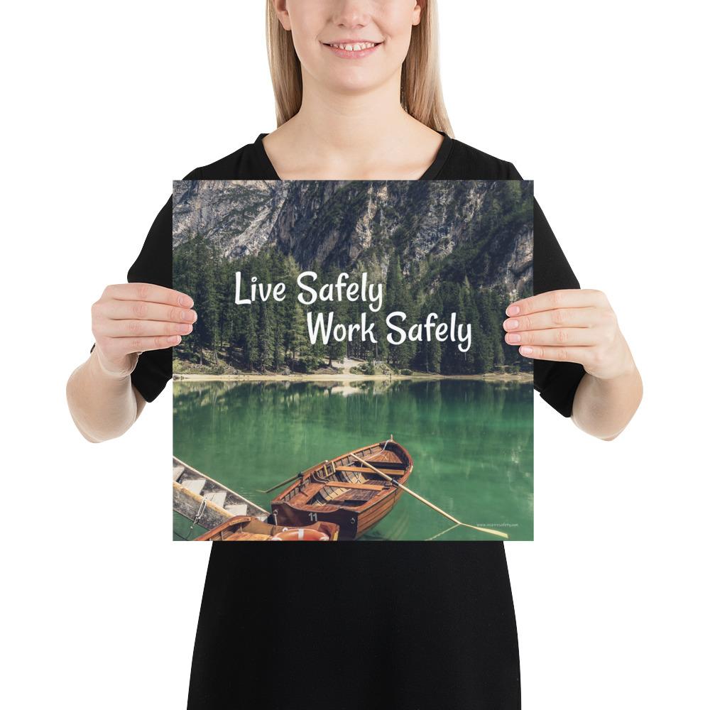 A workplace safety poster depicting a beautiful landscape of mountains in the background of a lake with a little wooden boat in the lake with text saying live safely work safely.