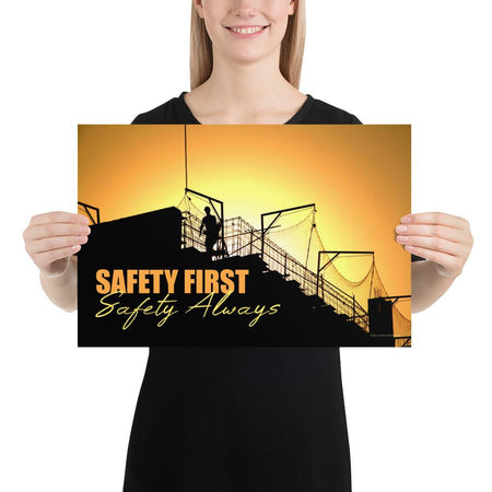 A workplace safety poster showing a construction site and construction workers being silhouetted by a bright and beautiful sunset of different shades of orange with the slogan safety first, safety always.