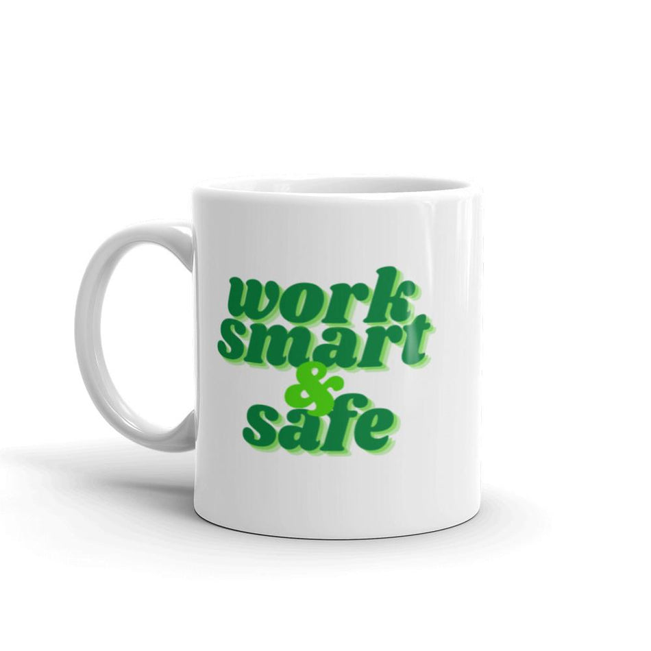 A white ceramic mug with bold green text that says "Work smart and safe."