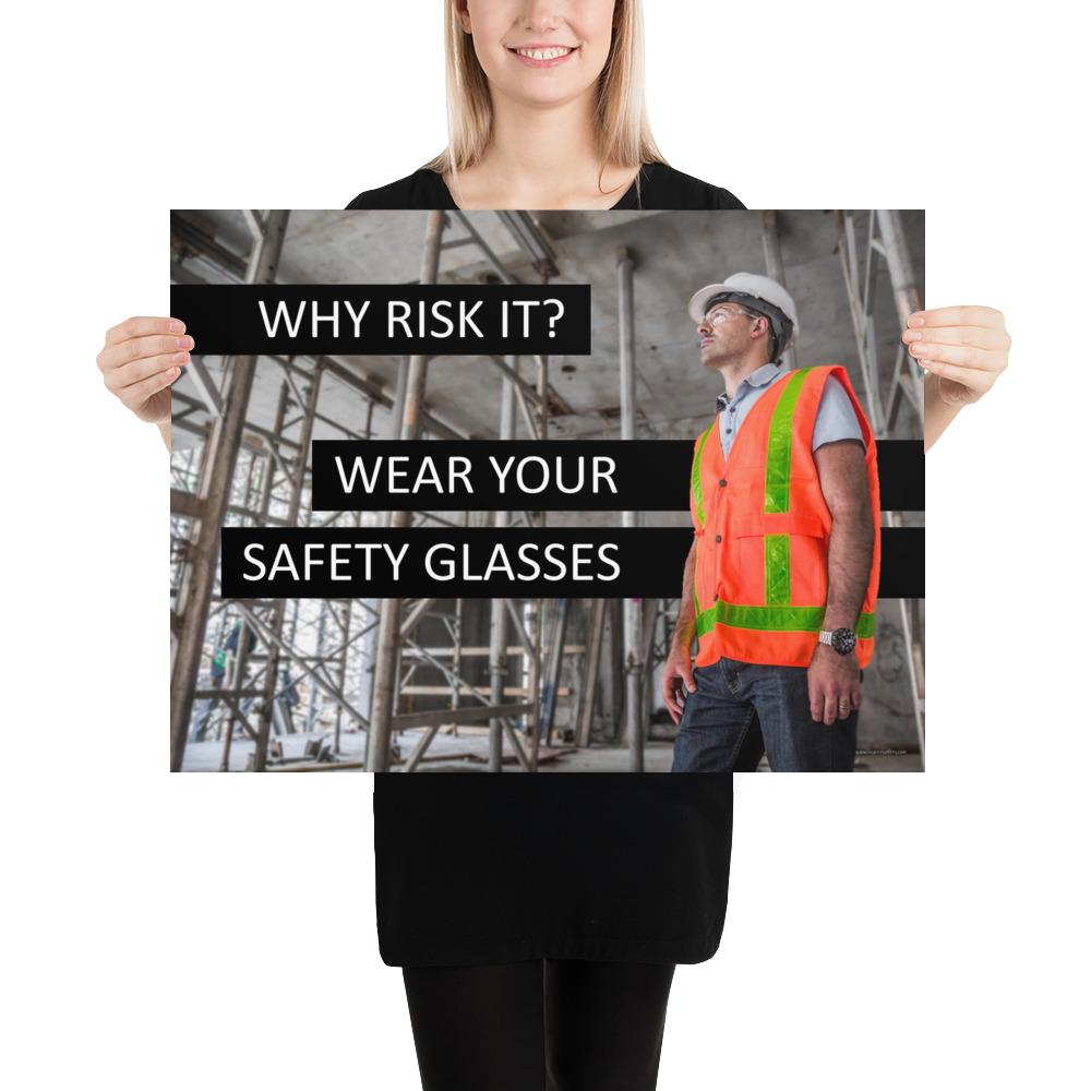 A safety poster showing a construction worker in a reflective orange vest, hard hat, and safety glasses on a construction site looking out with a safety slogan to the left.