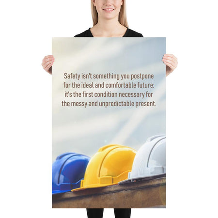 A workplace safety poster showing 3 multi colored hardhats sitting on a wall with the slogan safety isn't something you postpone for the ideal and comfortable future. It's the first condition necessary for the messy and unpredictable present.