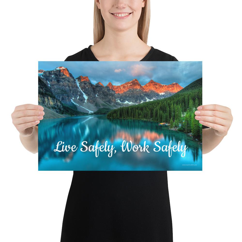 A workplace safety poster depicting a beautiful landscape of mountains with a river flowing down the side of the mountains into a bright blue pond with text saying live safely work safely.
