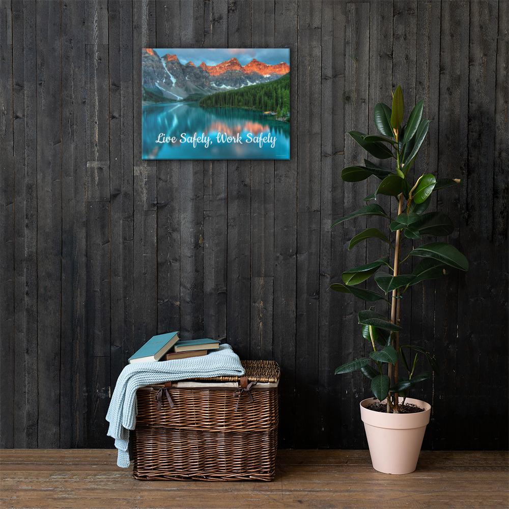 A workplace safety poster depicting a beautiful landscape of mountains with a river flowing down the side of the mountains into a bright blue pond with text saying live safely work safely.