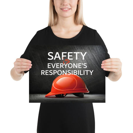 A workplace safety poster showing a red hard hat in front of a grey, industrial-looking background with the slogan safety is everyone's responsibility.