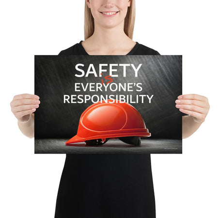 A workplace safety poster showing a red hard hat in front of a grey, industrial-looking background with the slogan safety is everyone's responsibility.