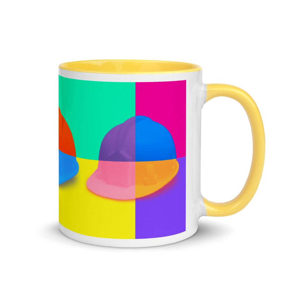 White ceramic mug with a bold hard hat pop art print with yellow color on the inside, the rim, and the handle.