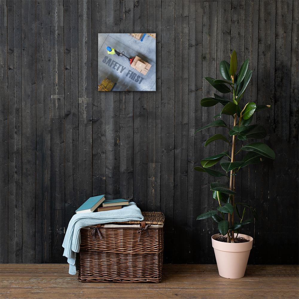 A safety poster showing a bird's-eye view of a worker in a warehouse pulling boxes on a pallet jack with the slogan safety first in bold letters.