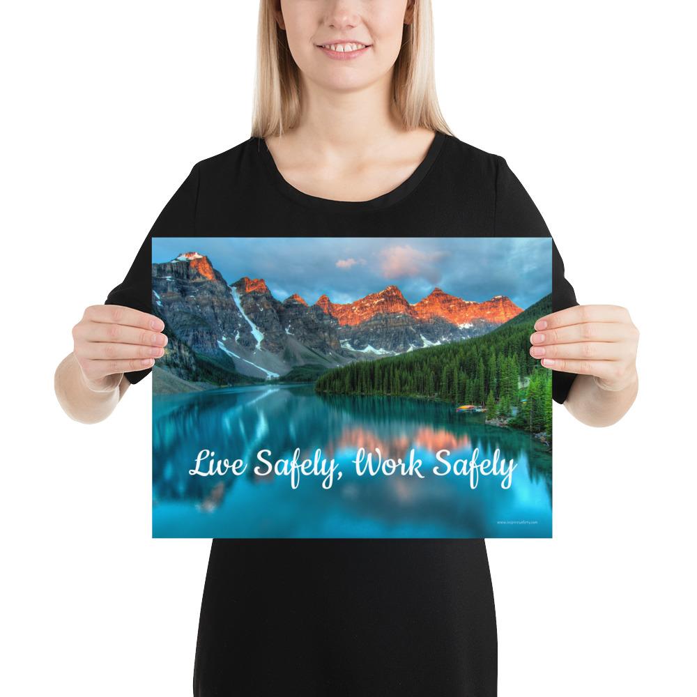 A workplace safety poster depicting a beautiful landscape of mountains with a river flowing down the side of the mountains into a bright blue pond with text saying live safely work safely.