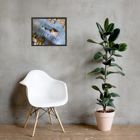 A safety poster showing a bird's-eye view of a worker in a warehouse pulling boxes on a pallet jack with the slogan safety first in bold letters.
