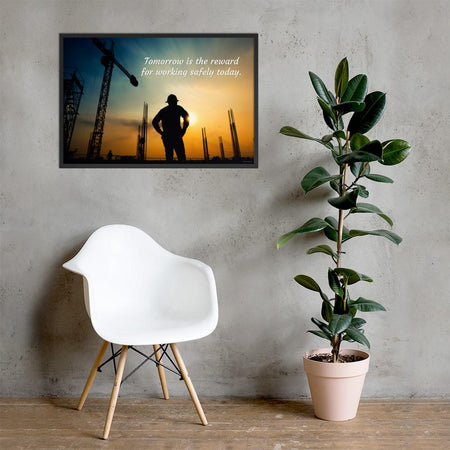 A safety poster showing a worker on a construction site being silhouetted by a sunset of orange and blue colors with the slogan tomorrow is the reward for working safely today.