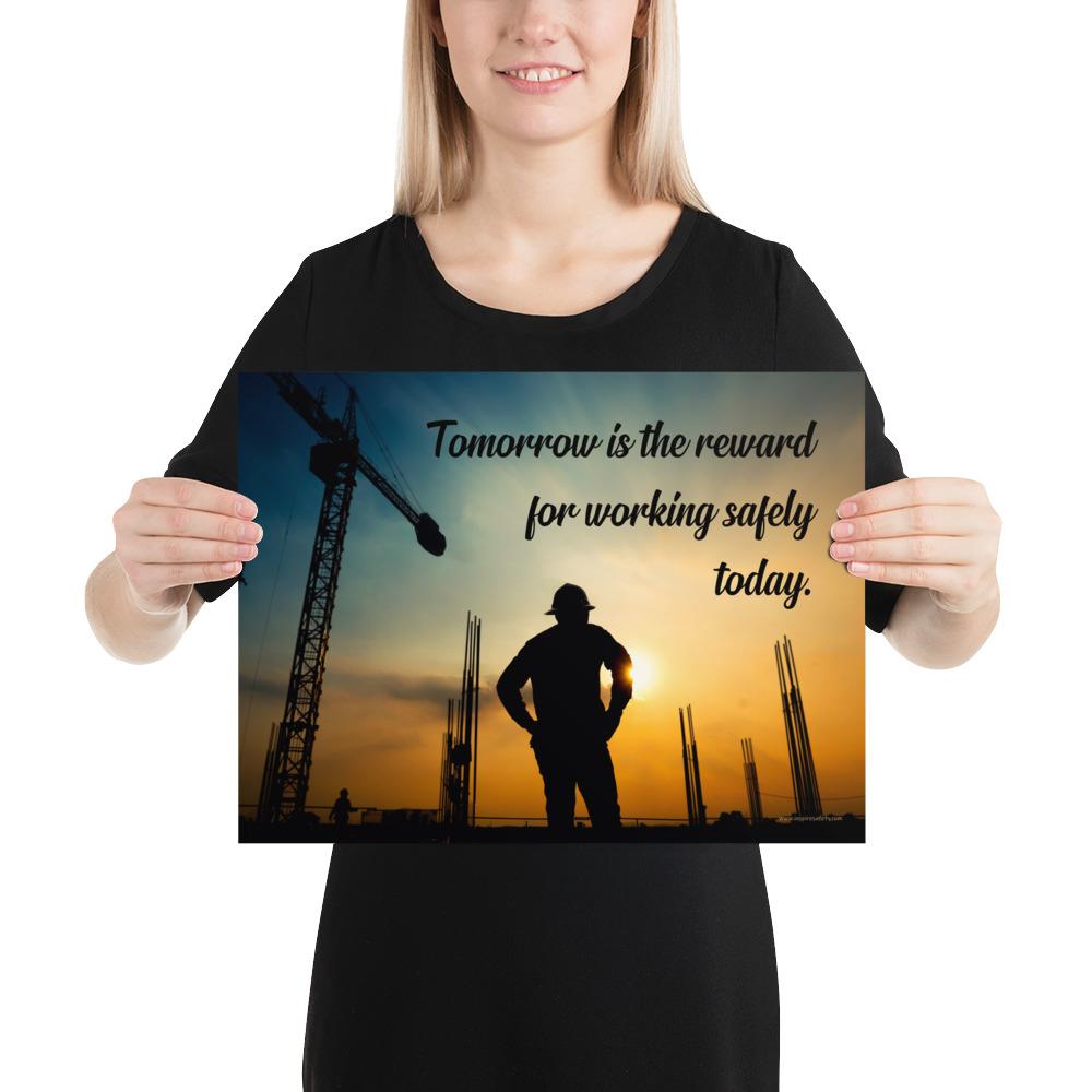 A safety poster showing a worker on a construction site being silhouetted by a sunset of orange and blue colors with the slogan tomorrow is the reward for working safely today.