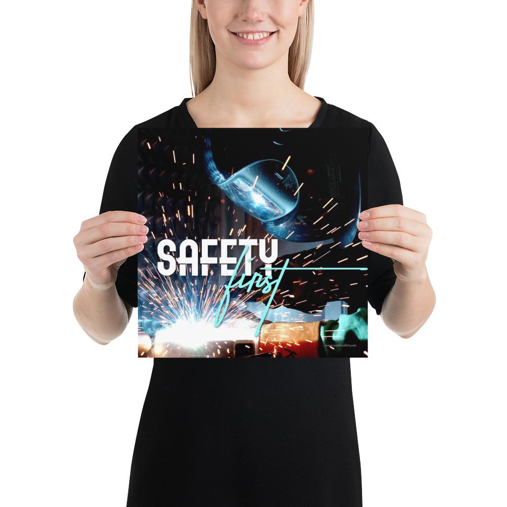 A safety poster showing a close-up of a welder welding a pipe while wearing a welding hood with bright sparks flying all around with the slogan safety first.