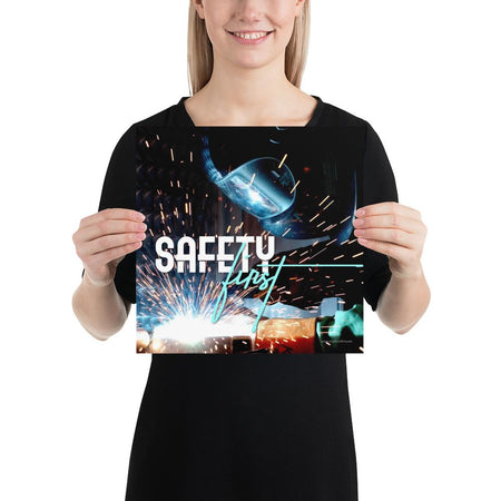 A safety poster showing a close-up of a welder welding a pipe while wearing a welding hood with bright sparks flying all around with the slogan safety first.