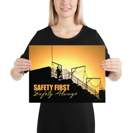 A workplace safety poster showing a construction site and construction workers being silhouetted by a bright and beautiful sunset of different shades of orange with the slogan safety first, safety always.