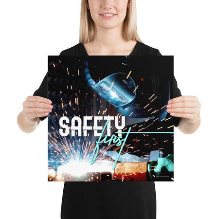 A safety poster showing a close-up of a welder welding a pipe while wearing a welding hood with bright sparks flying all around with the slogan safety first.