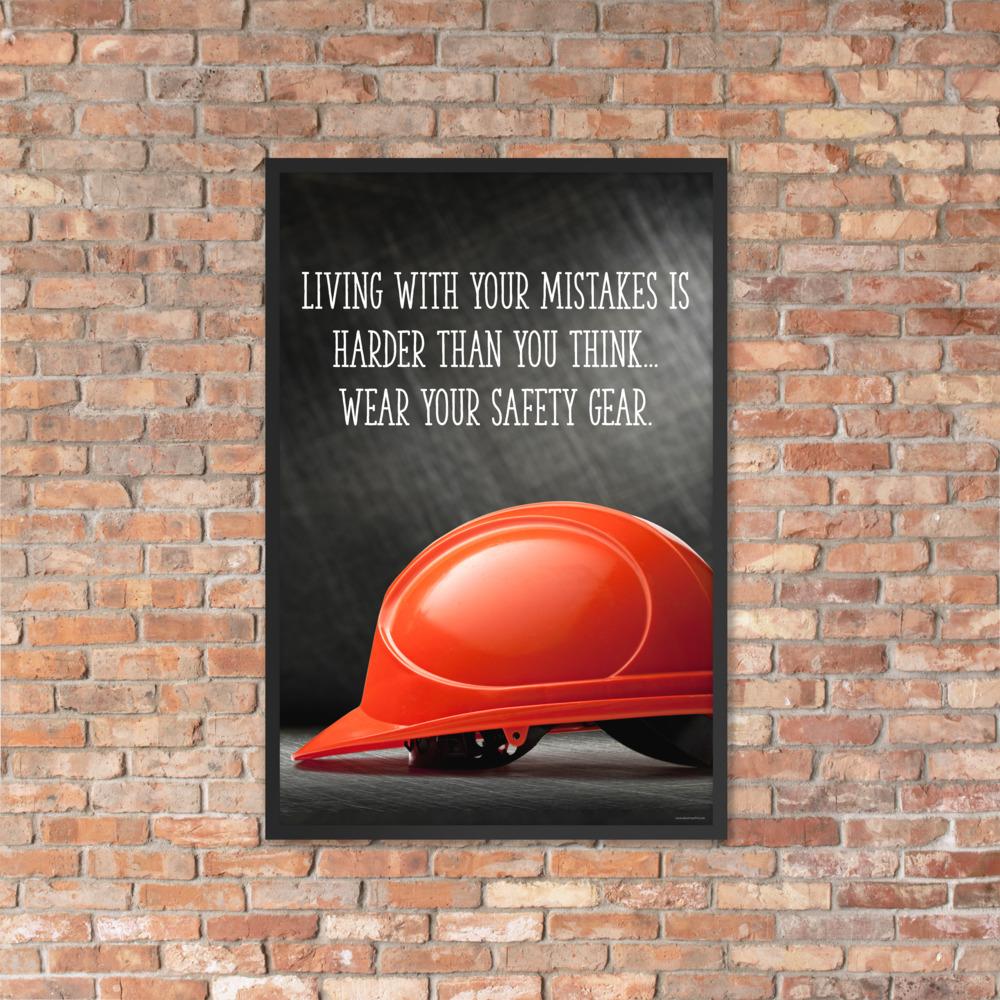 A workplace safety poster showing a bright red hard hat with an ominous black background with the slogan living with your mistakes is harder than you think, wear your safety gear.