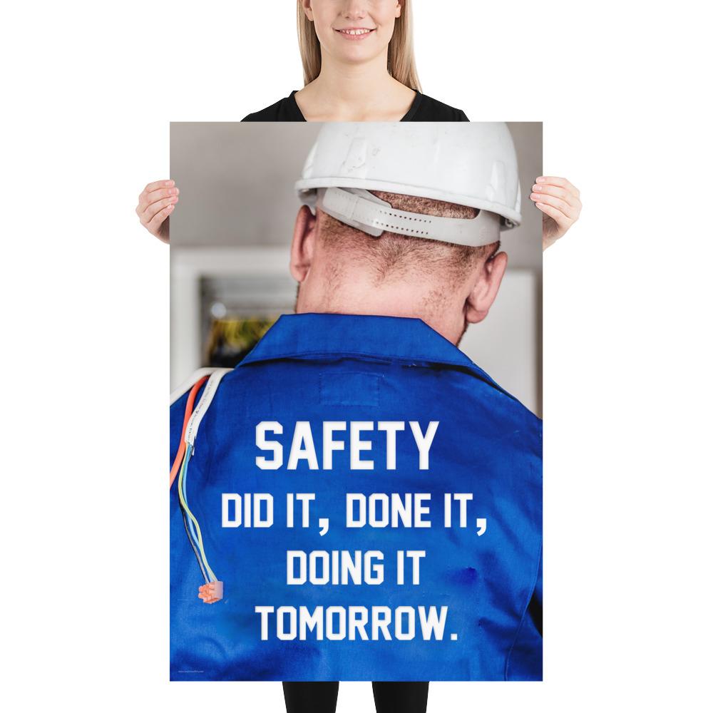 Safety poster showing an electrician wearing a hard hat and holding cables working on an electrical panel with text on the back of his bright blue shirt.
