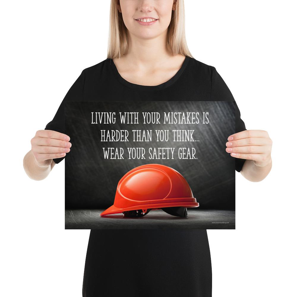 A workplace safety poster showing a bright red hard hat with an ominous black background with the slogan living with your mistakes is harder than you think, wear your safety gear.