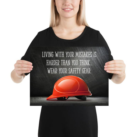 A workplace safety poster showing a bright red hard hat with an ominous black background with the slogan living with your mistakes is harder than you think, wear your safety gear.