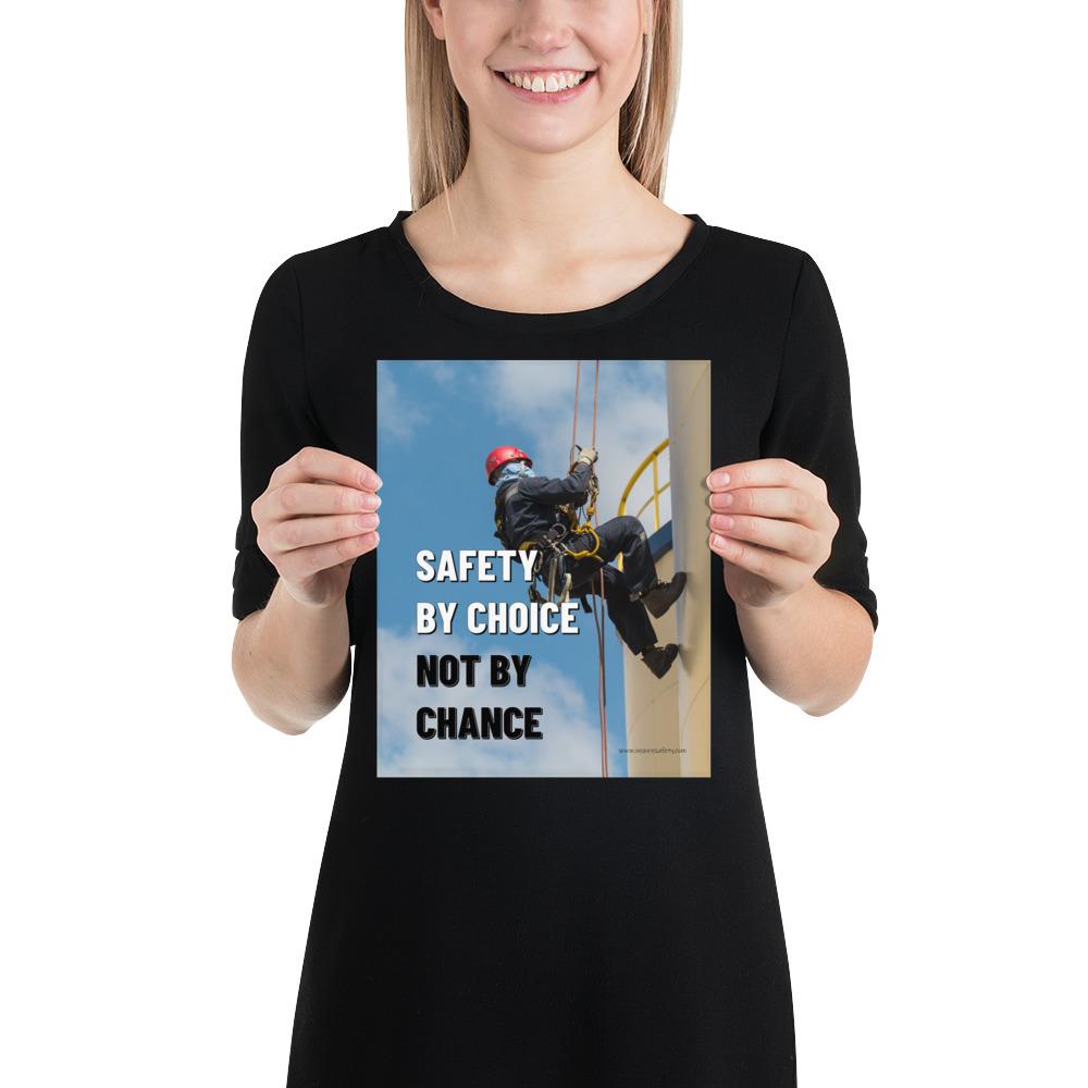 A fully harnessed man wearing a hard hat scaling the side of a building with a bright blue sky and clouds in the background with the text safety by choice, not by chance in bold text to his left.