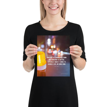 A workplace safety poster depicting a bright orange construction traffic light in the foreground of a blurry nighttime cityscape with a safety quote by William Blake.