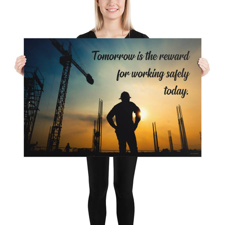 A safety poster showing a worker on a construction site being silhouetted by a sunset of orange and blue colors with the slogan tomorrow is the reward for working safely today.