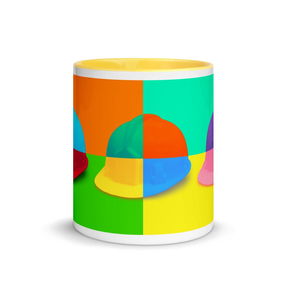 White ceramic mug with a bold hard hat pop art print with yellow color on the inside, the rim, and the handle.